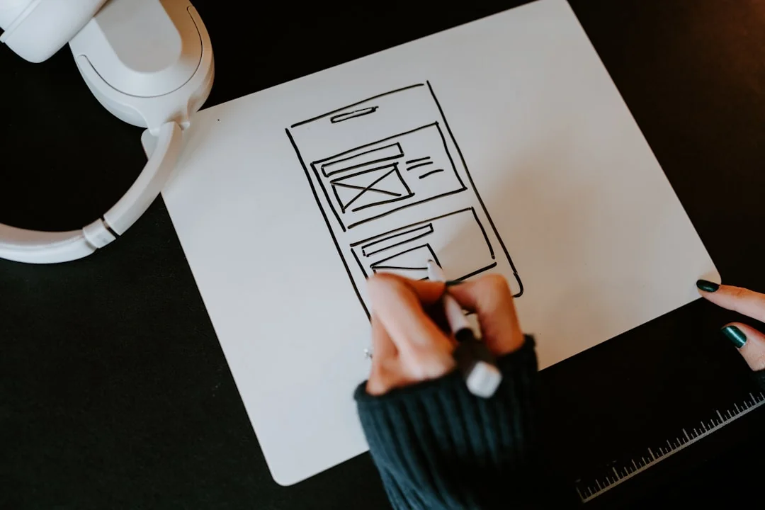 A laptop on a bed showing web design software, creating a cozy workspace.